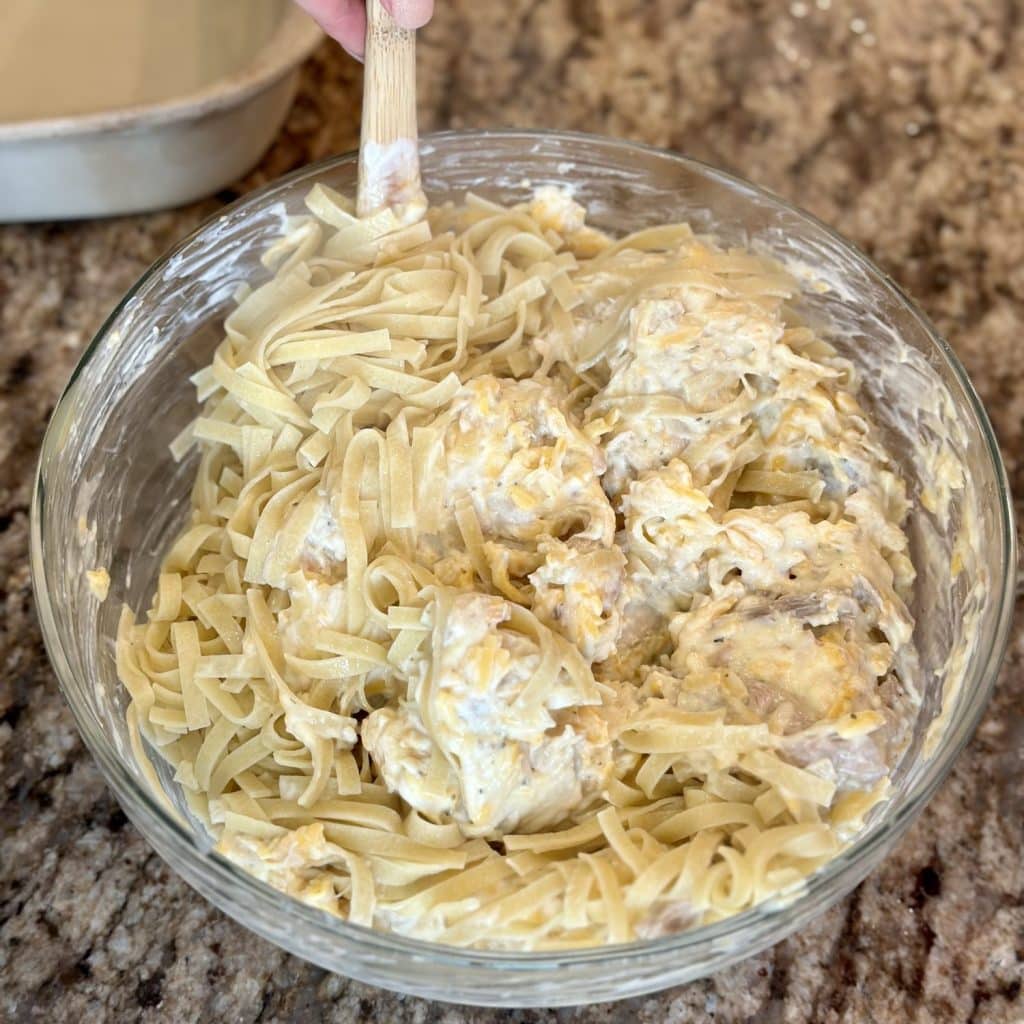 Mixing a chicken bake mixture of ingredients in a large bowl.