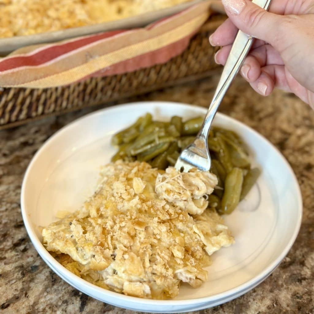 A fork going in for a bite of a chicken pasta bake.