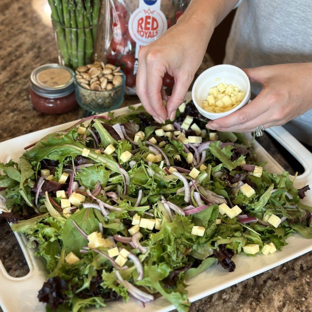 Garnishing a salad with cheese.