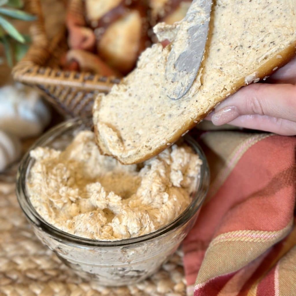 Garlic butter being spread on bread.