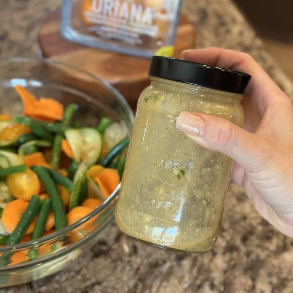 Mixing green bean salad dressing in a bowl.