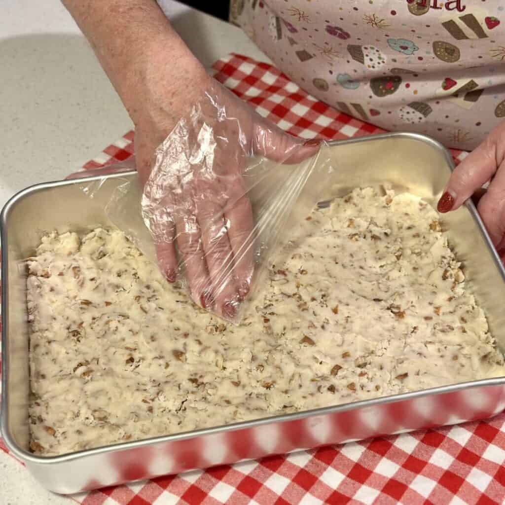 Patting down a shortbread crust in a pan.