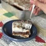 A slice of chocolate peanut butter layered dessert on a saucer.