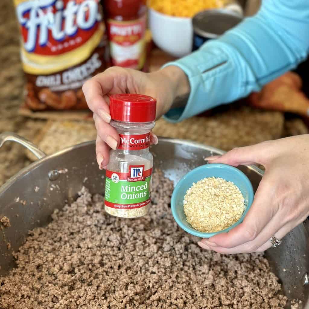 Adding seasonings to beef in a skillet.