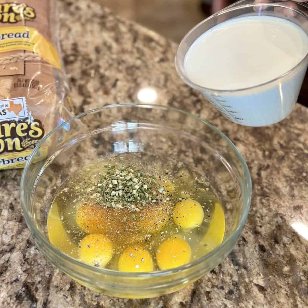 Adding milk to a bowl of ingredients for a sausage casserole.