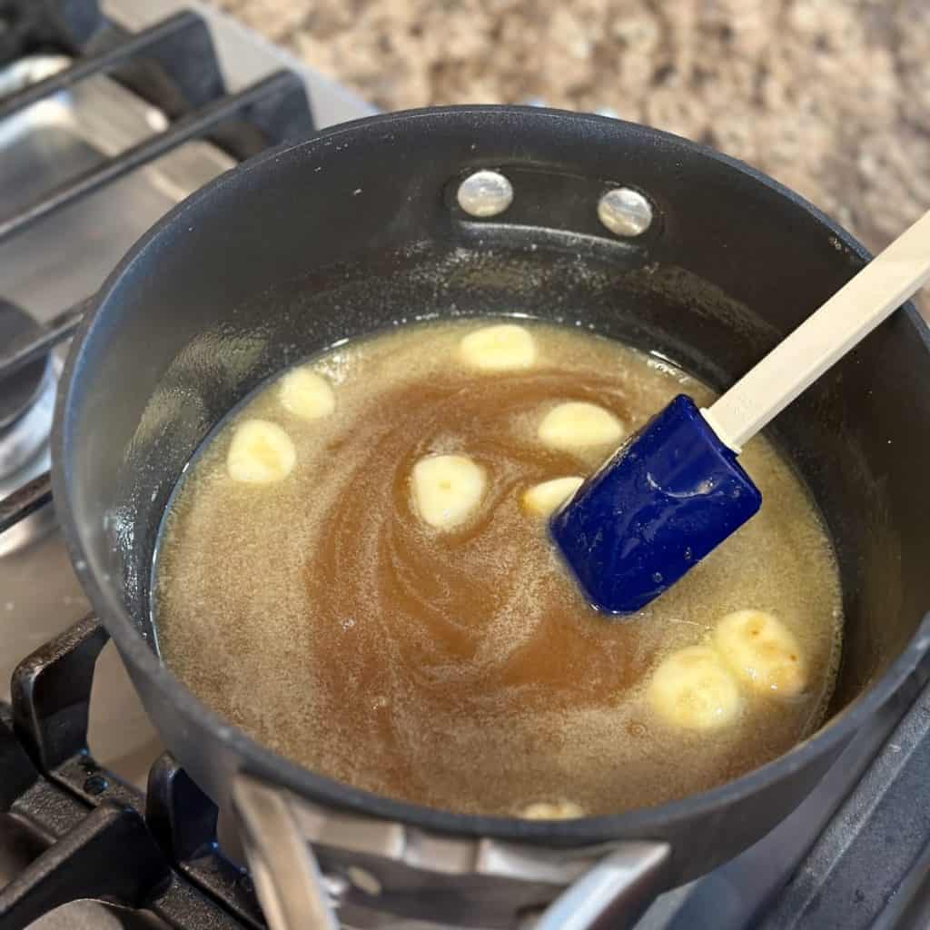 Mixing the ingredients in a small sauce pan for caramel Chex mix.