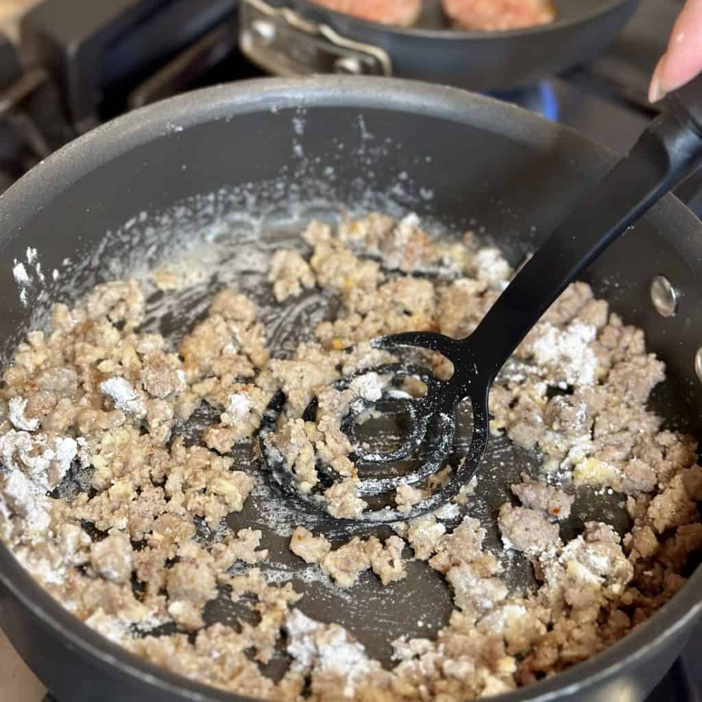 Stirring flour into breakfast gravy.