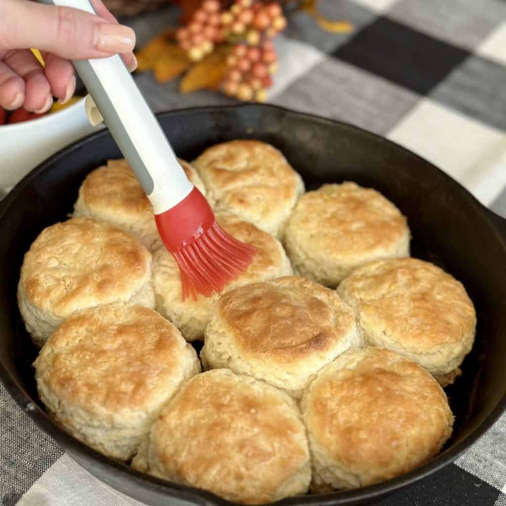 Brushing butter on biscuits.