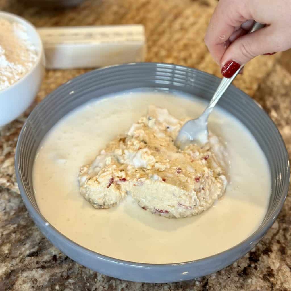 Mixing together buttermilk and pimento cheese.