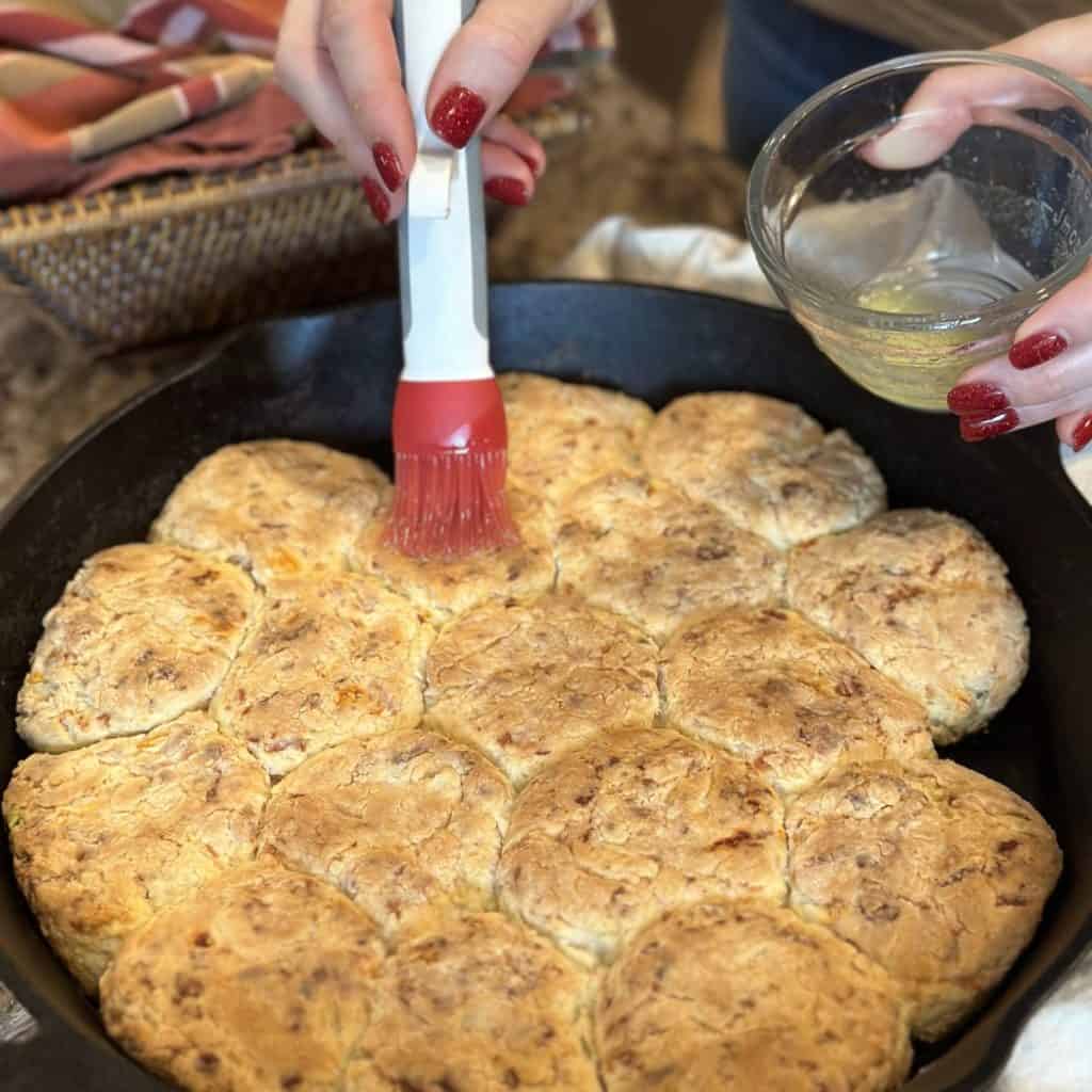 Brushing biscuits with butter.