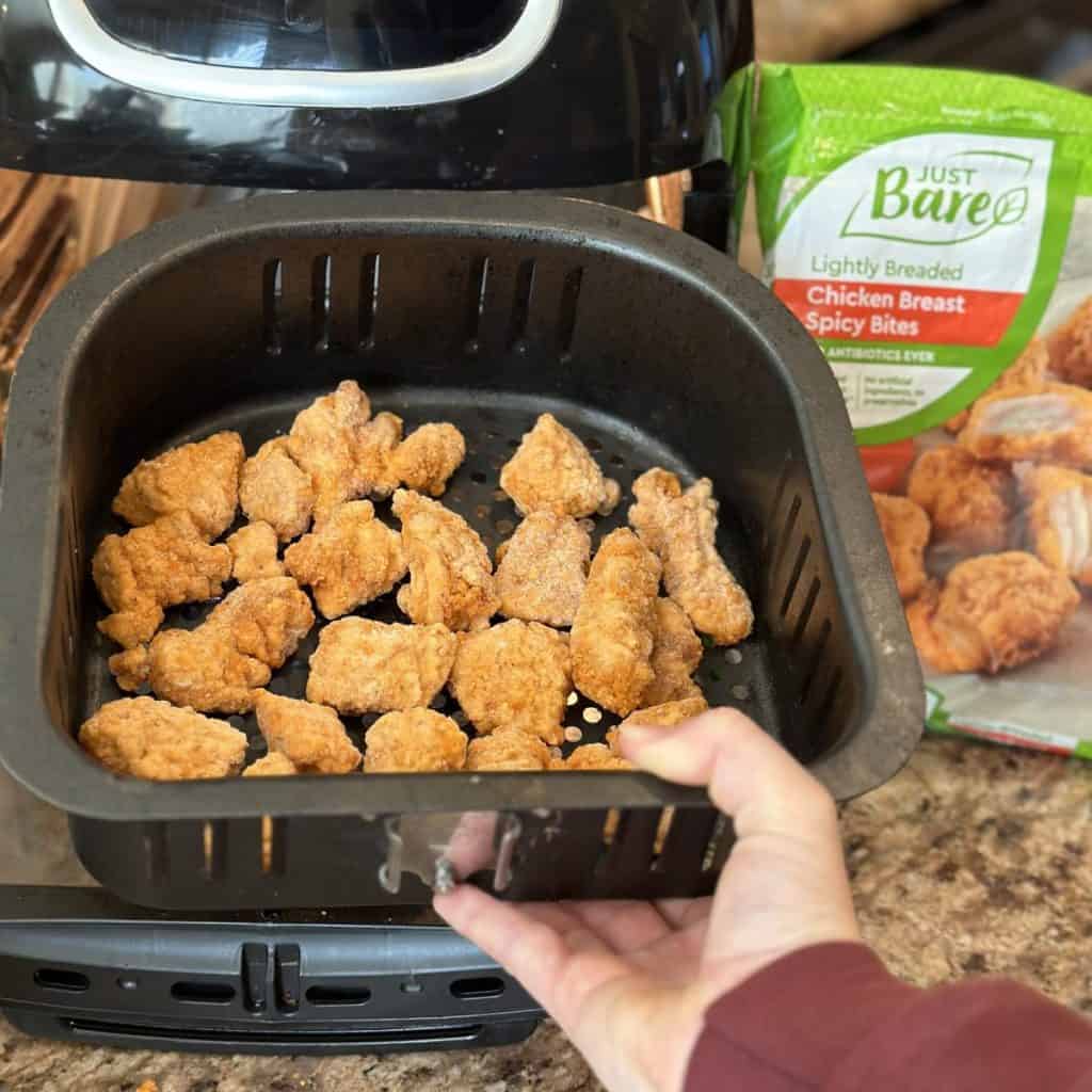 Putting chicken in an airfryer.