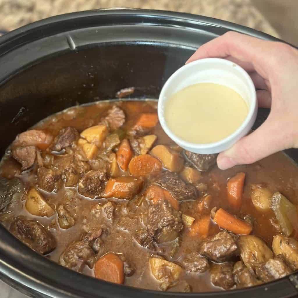 Adding a cornstarch slurry to a slow cooker.