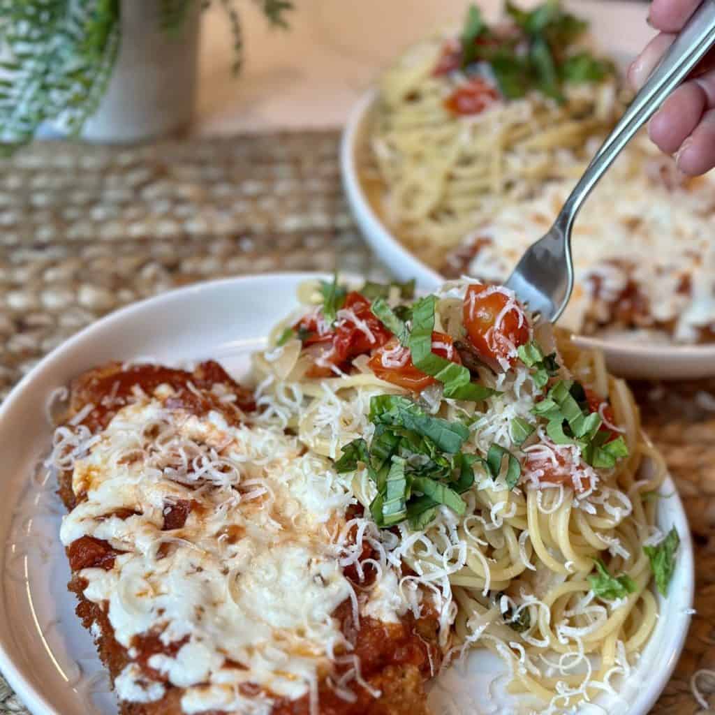 A plate of chicken parmesan and pasta.