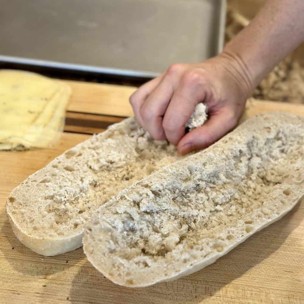 Scooping out the inside of a bread roll.