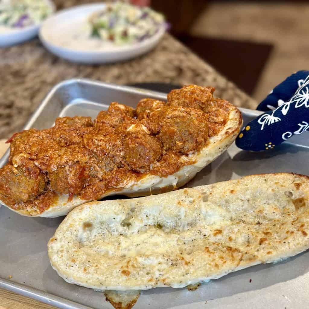 A sheet pan with meatball sub on top.