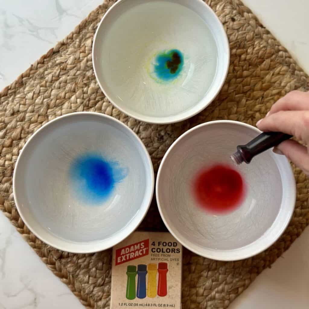 Adding food coloring to water.