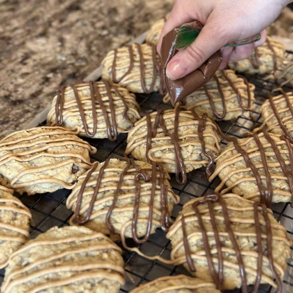 Drizzling chocolate on top of a cookie.