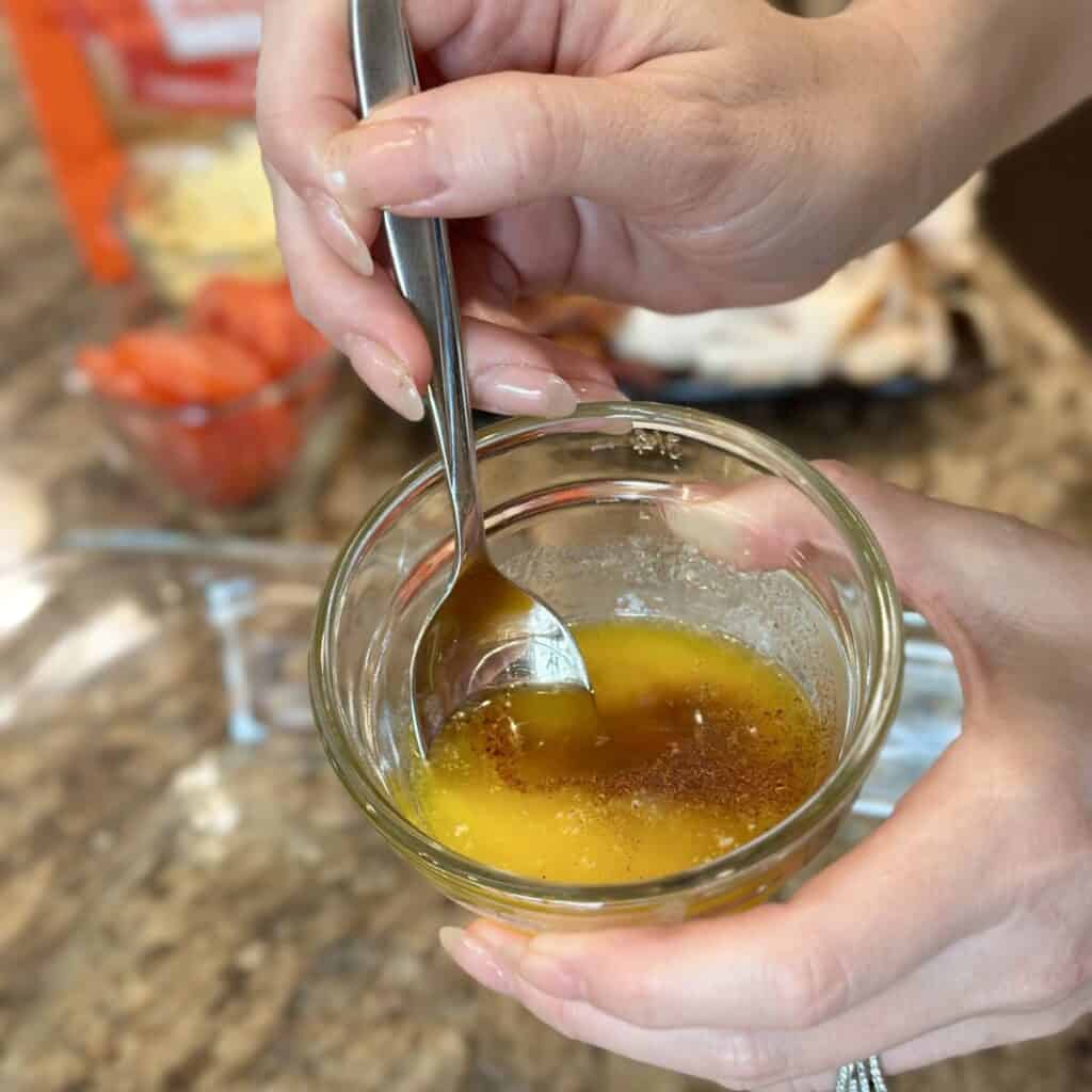 Mixing together butter and seasonings.