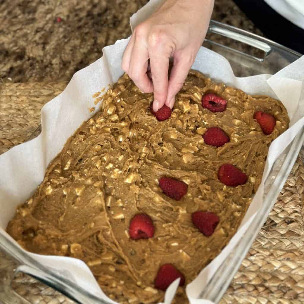 Pressing raspberries in a chess bar batter.