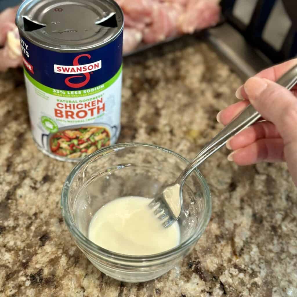 Mixing a cornstarch slurry in a bowl.