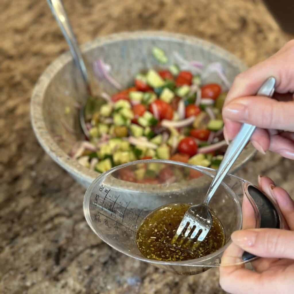 Whisking together ingredient in a measuring cup for dressing.