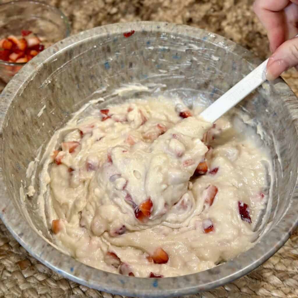 Folding strawberries into pound cake batter.