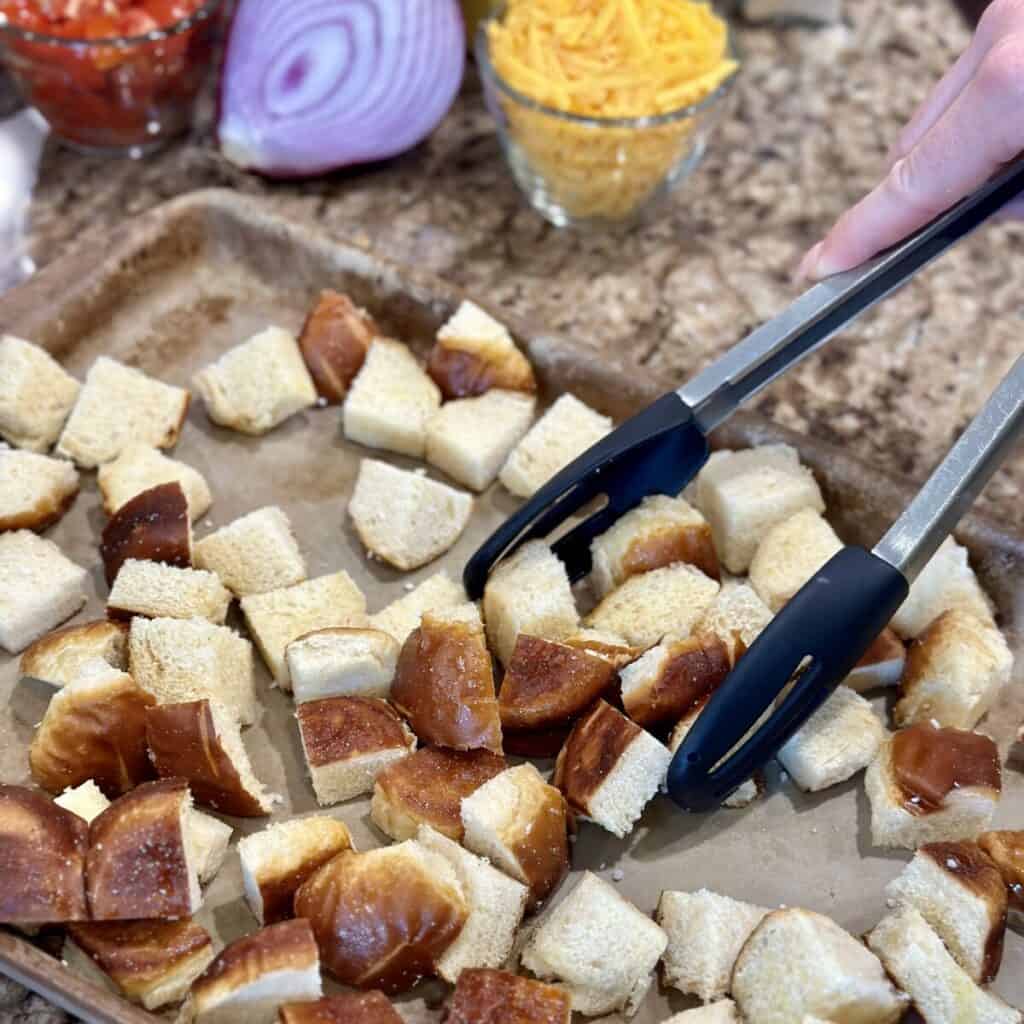 Tossing bread on a sheet pan.