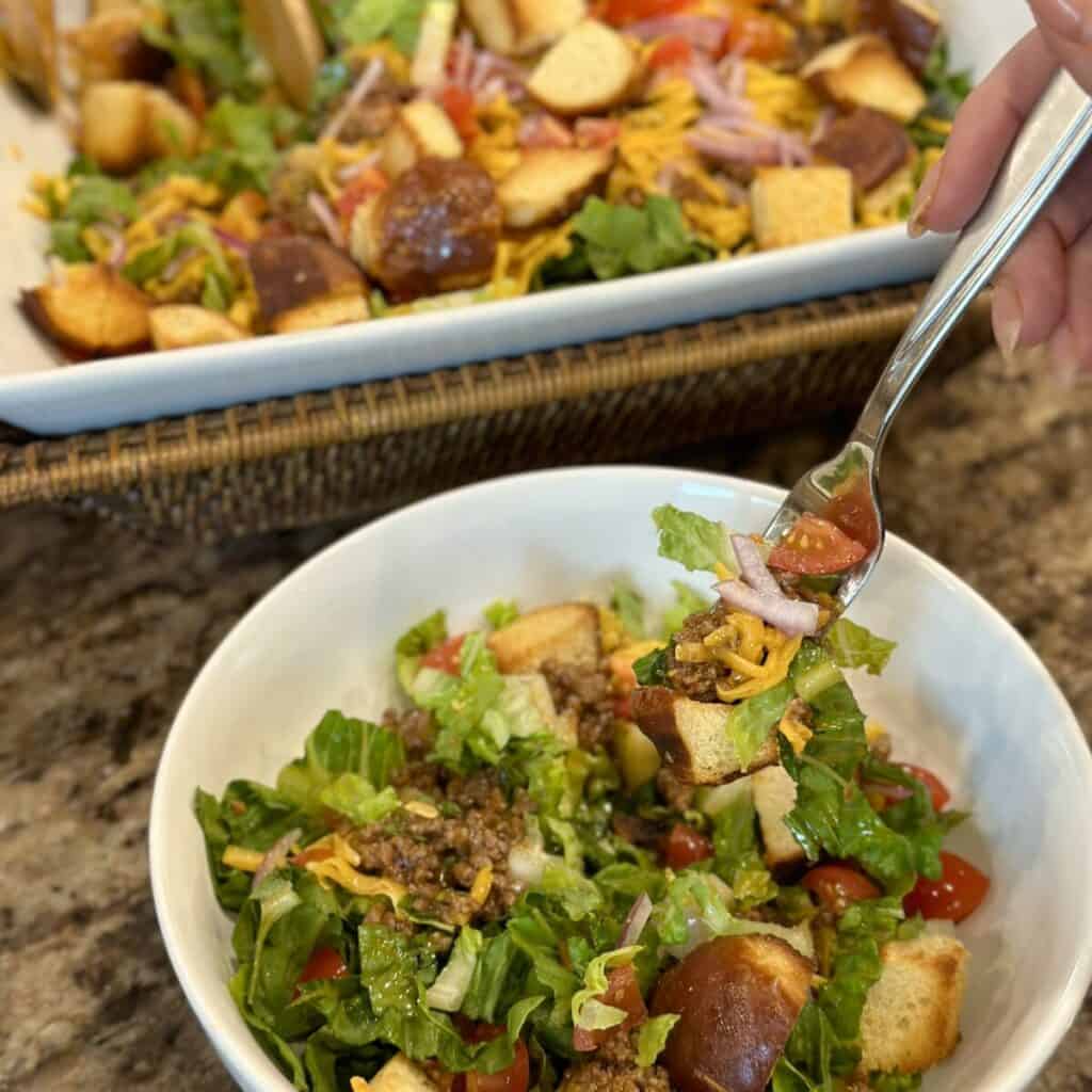 Getting a bite on a fork of burger salad.