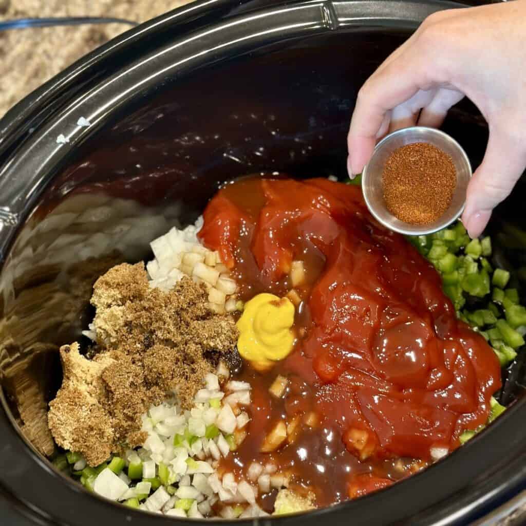 Combining ingredients for slow cooker sloppy joes in the crockpot.