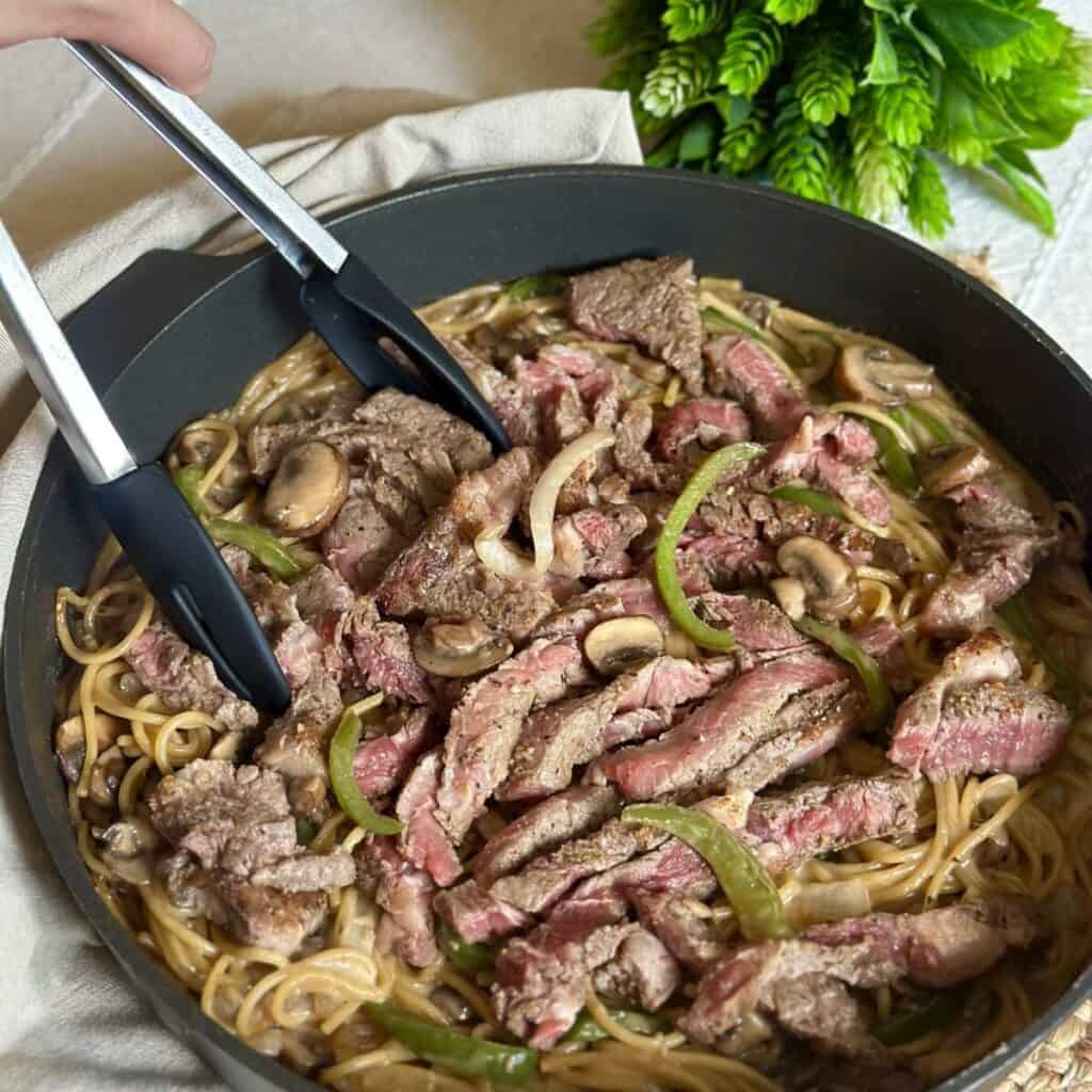 Getting a scoop of cheesesteak pasta.