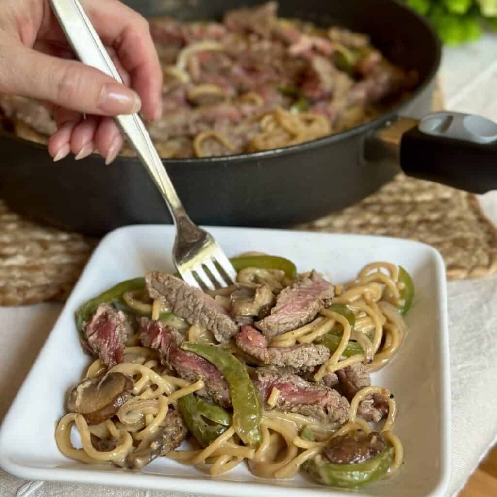 Getting a forkful of cheesesteak pasta.