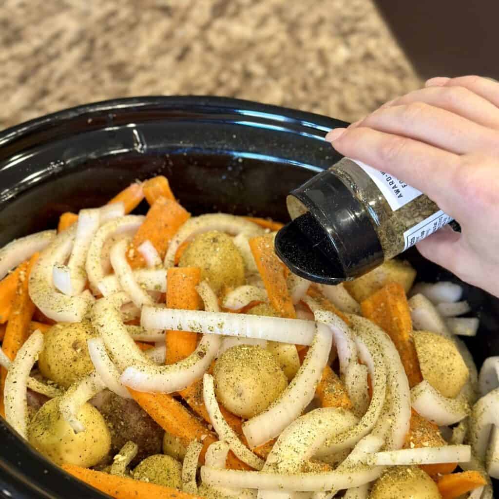 Adding seasoning to crockpot country style ribs.