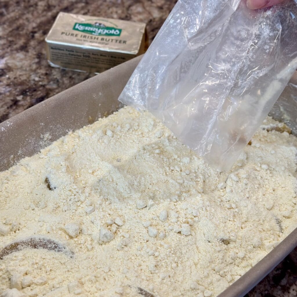 Adding cake mix to the top of peaches in a casserole dish.