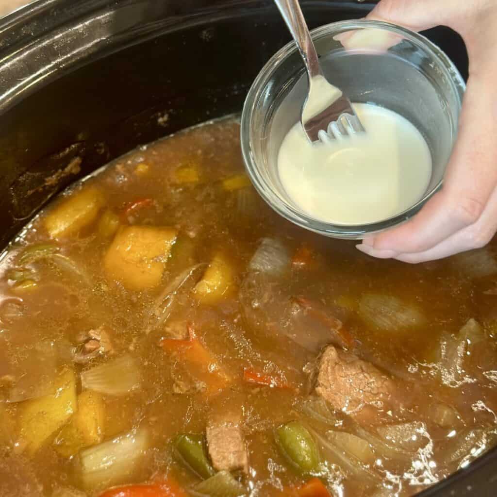 Adding a cornstarch slurry to crockpot pepper steak.