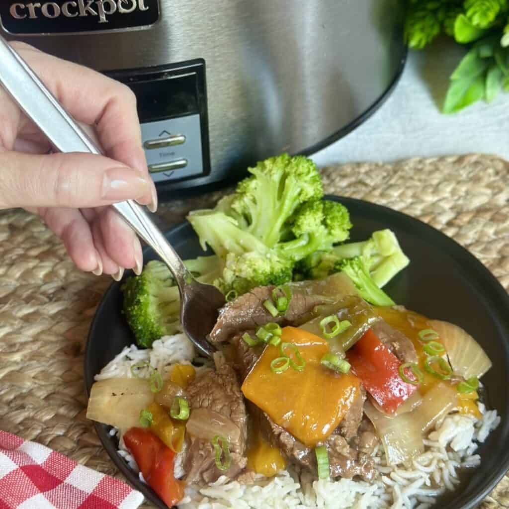 Slow cooker pepper steak and rice with veggies on a plate.