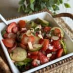 Getting a spoonful of cucumber and strawberry salad.