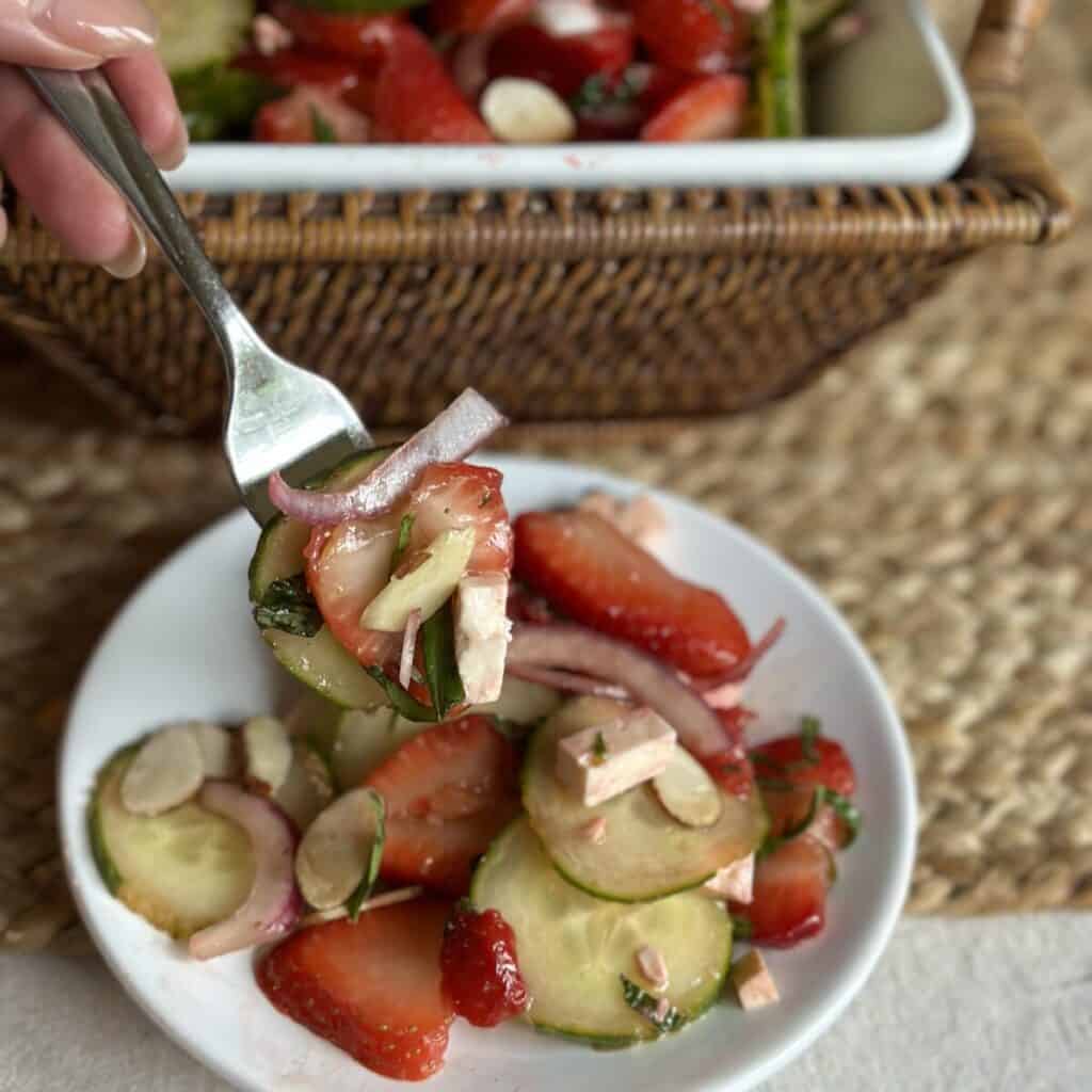 Getting a forkful of cucumber and strawberry salad.