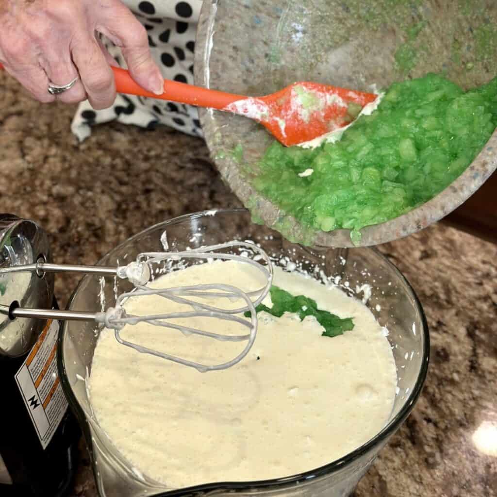 Adding pineapple jello to cream cheese and cool whip.