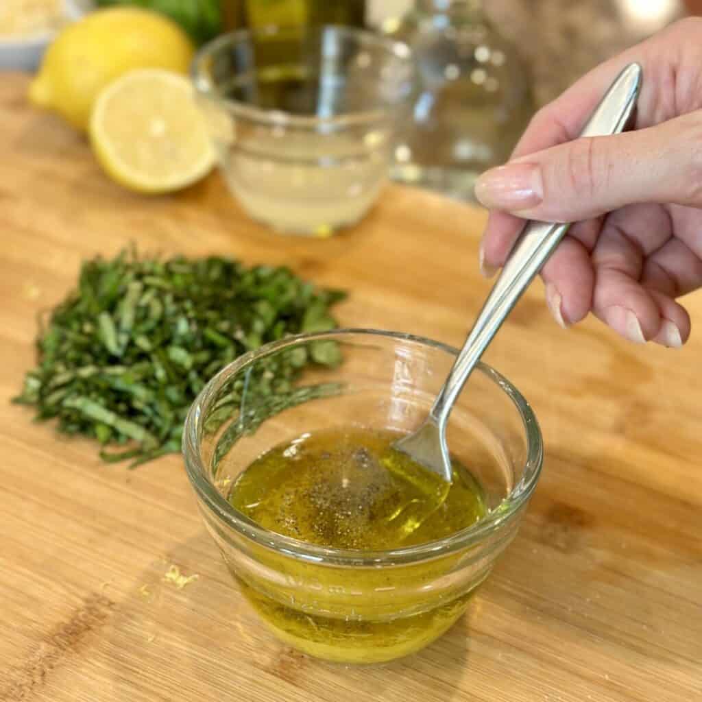 Making dressing in a small bowl for pasta salad.