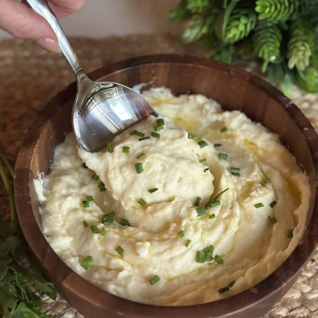 A spoon in a bowl of mashed potatoes.