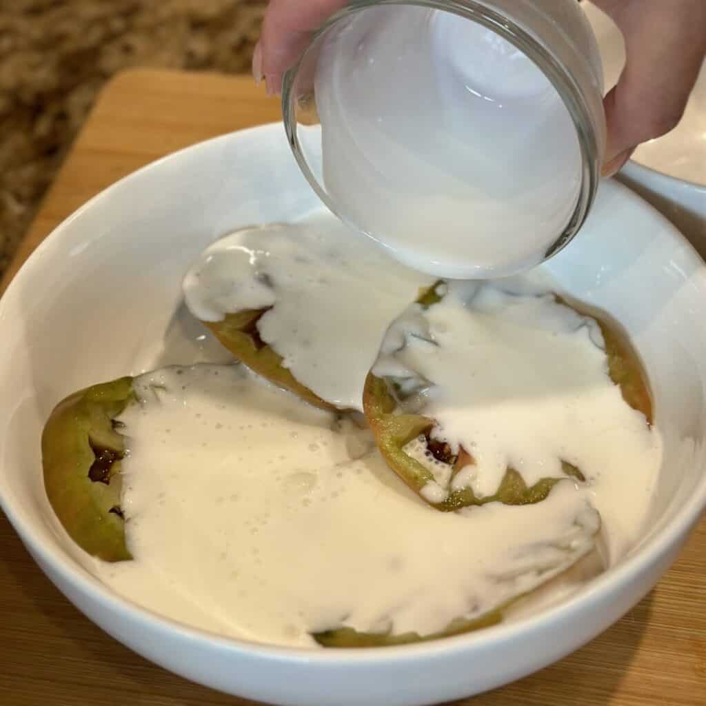 Pouring buttermilk over green tomatoes.