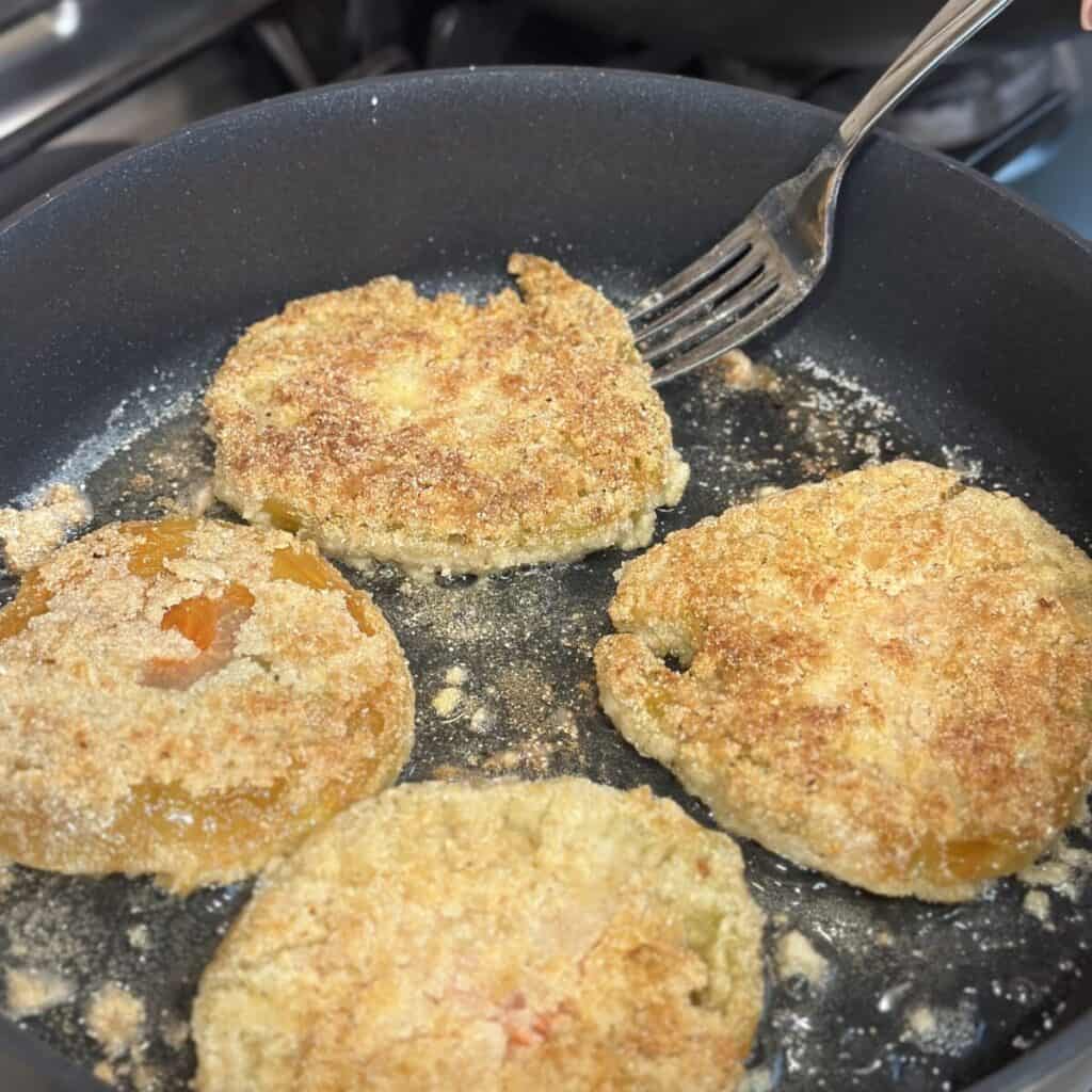 Frying green tomatoes in a skillet.