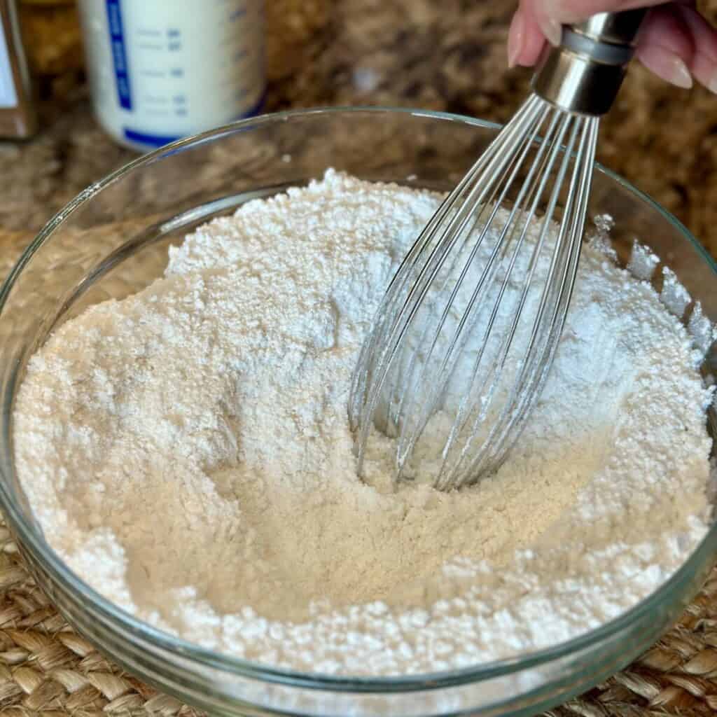 Whisking flour in a bowl.