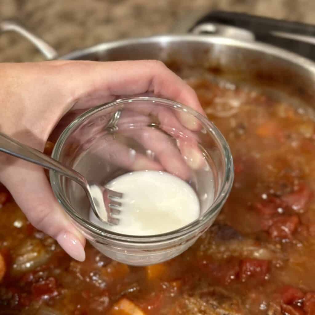 Whisking together a cornstarch slurry.