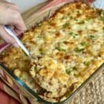 A spoon of cooked cheesy ham and potato casserole.