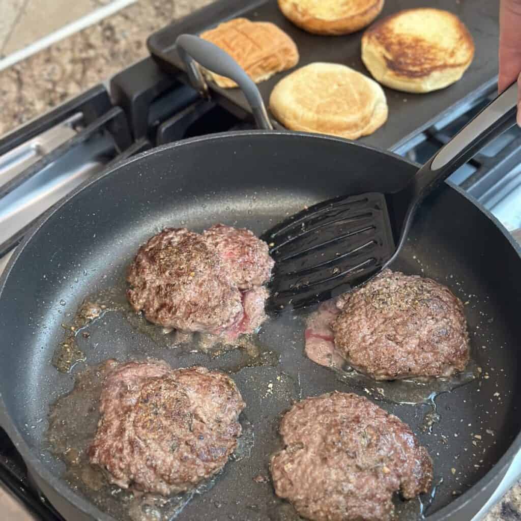 Flipping burger in a skillet.