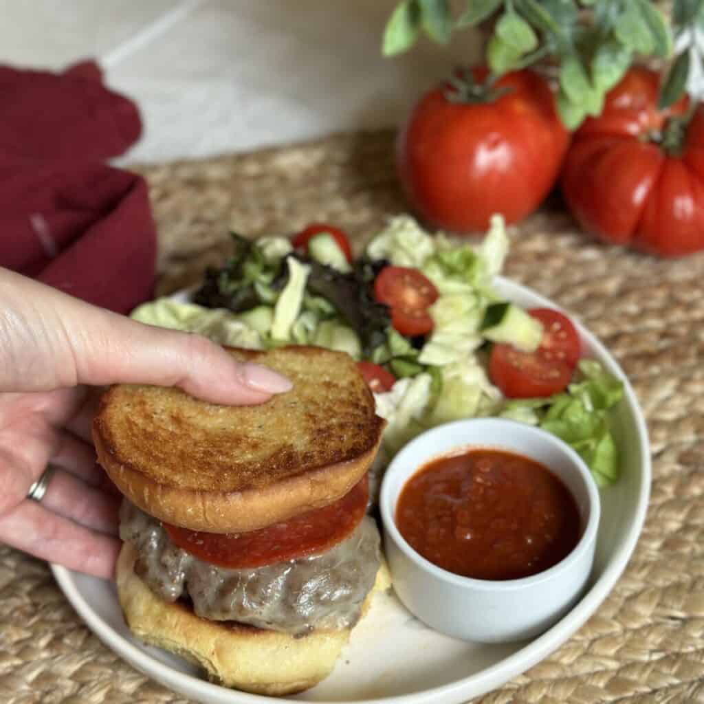 Holding a pizza burger.