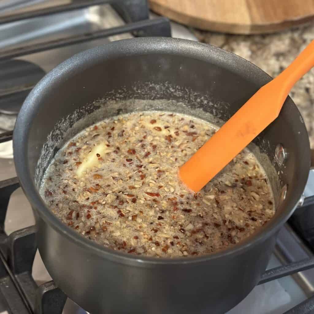 Making the topping for fruit cocktail cake in a saucepan.