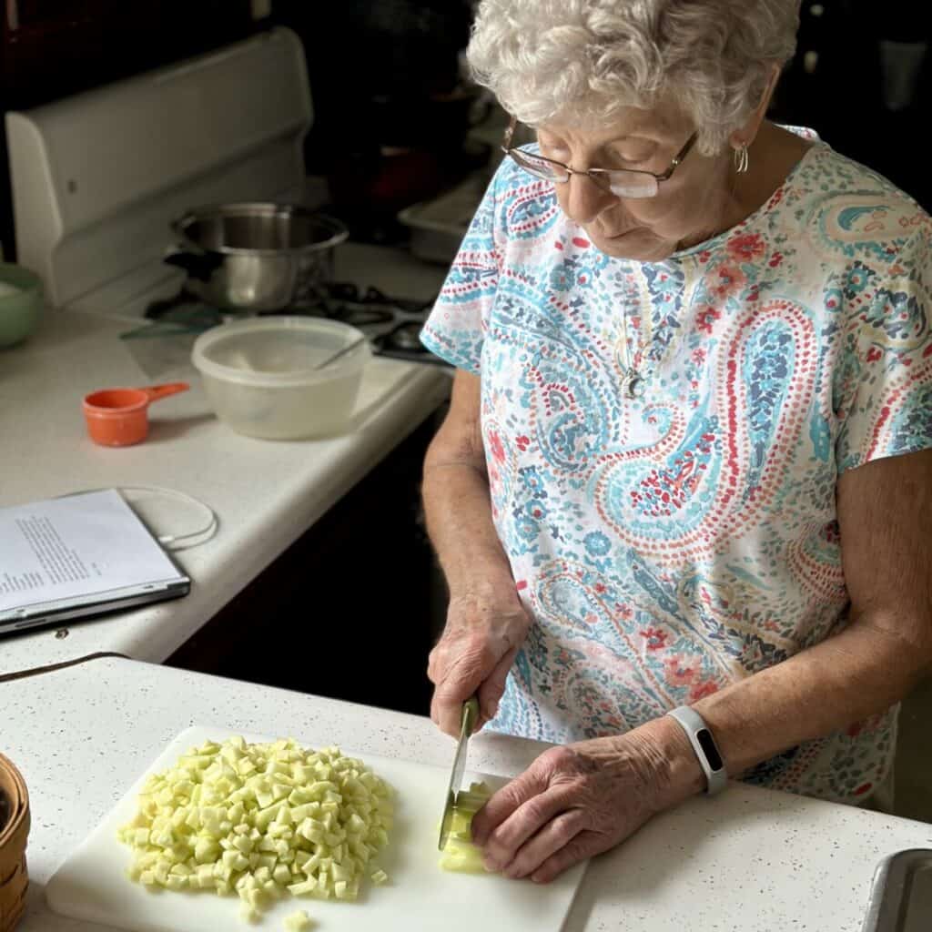 A grandmother chopping up apples.