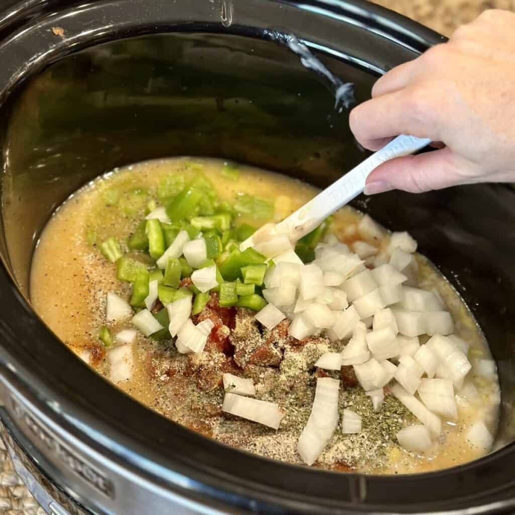 Adding the ingredients for the sauce for crock pot chicken spaghetti.